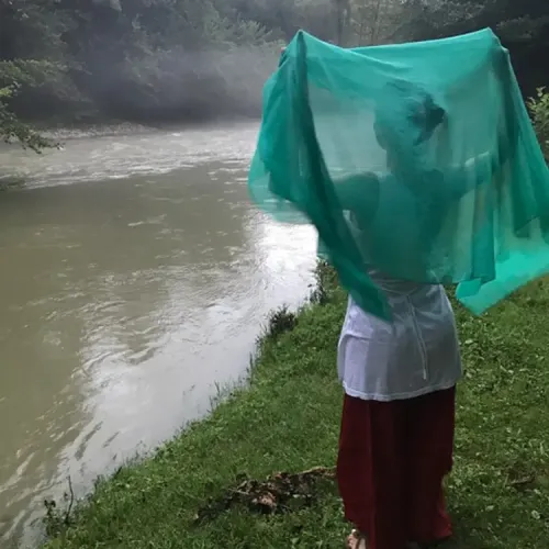 Helen looking out over a river in Georgia, with a green scarf