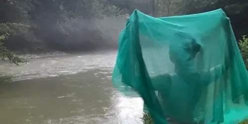 Helen looking out over a river in Georgia, with a green scarf