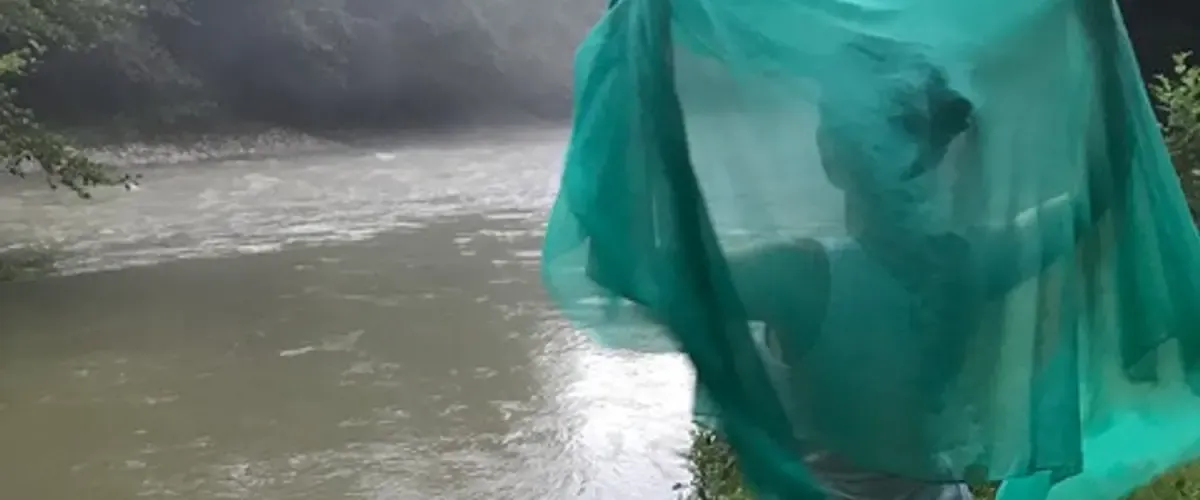 Helen looking out over a river in Georgia, with a green scarf