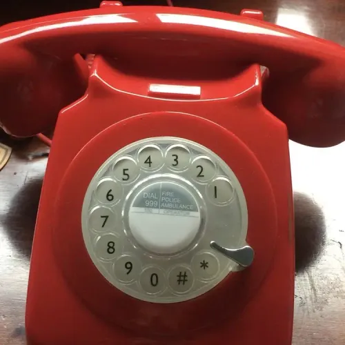 Red telephone on a wooden table