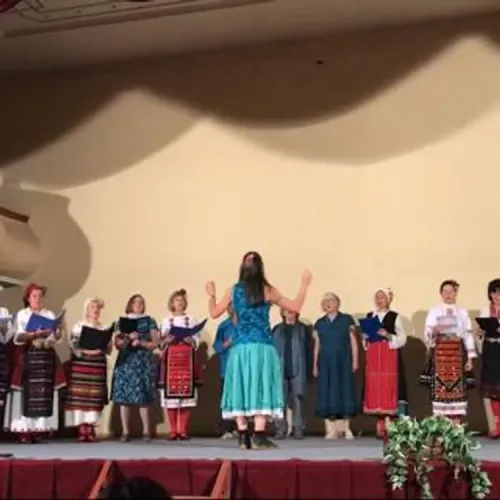 Helen conducts a Bulgarian choir wearing traditional dress, and Zarebi members