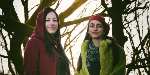Calluna Sun stand in a woodland and smile at the camera