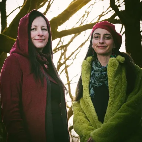 Calluna Sun stand in a woodland and smile at the camera